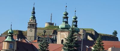 Kłodzko Miasto [Widok z dworca autobusowego w Kłodzku na twierdzę, a na jej tle wieże kościoła MB Różańcowej i klasztoru franciszkanów oraz wieża ratuszowa]