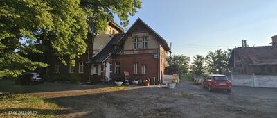 Ostroróg, ul. Dworcowa [Tutaj zaczyna się szlak. Na ścianie budynku za różami jest odmalowana początkowa/końcowa kropka.]